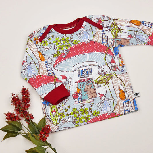 Langärmeliges Babyshirt ‚Zwergenwelt‘ aus Bio-Jersey mit Wichtel- und Waldtiermotiv, roter Bündchenfarbe und amerikanischem Ausschnitt