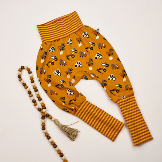 Kinder-Knickerbocker „Baustelle“ in Senfgelb mit Baustellenfahrzeugen und Ringelbündchen in Senfgelb-orange.
